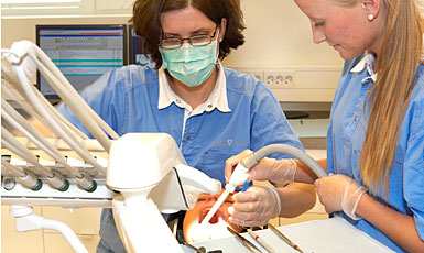 Bilde av tannbehandling med tannlege og assistent